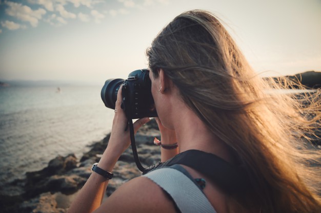 closeup-focus-shot-woman-taking-picture-sea-concept-photography_181624-35137